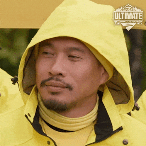 a man wearing a yellow jacket with a hood and a canada 's ultimate challenge logo