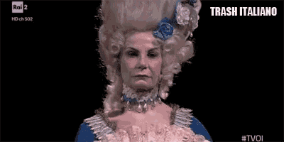 a woman wearing a wig and a blue dress is on a television screen .