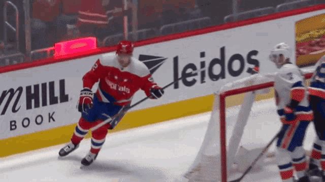 a hockey game is being played in front of an ad for leidos