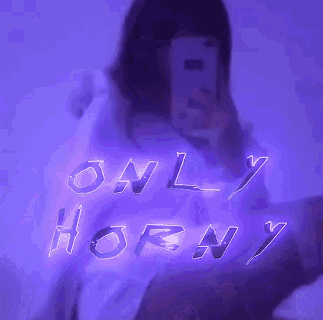 a woman is taking a selfie in front of a sign that says ' only horny '