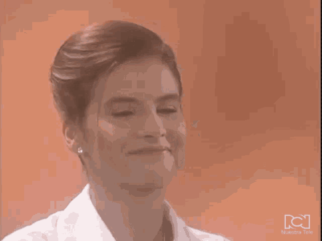 a close up of a woman 's face with a nuestra tele logo in the corner