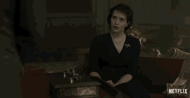 a woman sits on a couch with the word nothing on the bottom right