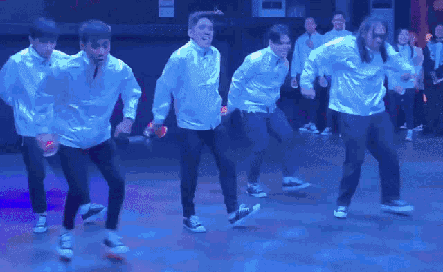 a group of men are dancing on a stage