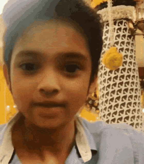 a close up of a young boy 's face with a yellow flower in the foreground