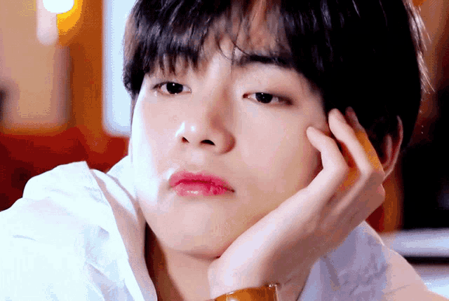 a close up of a man 's face with his hand on his face
