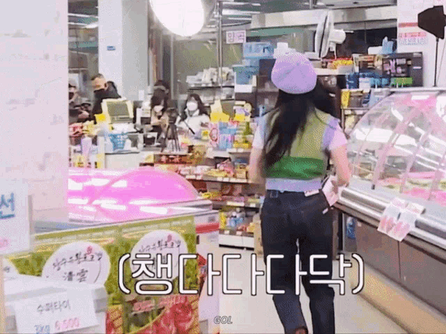 a woman wearing a purple hat and a green vest is walking through a store