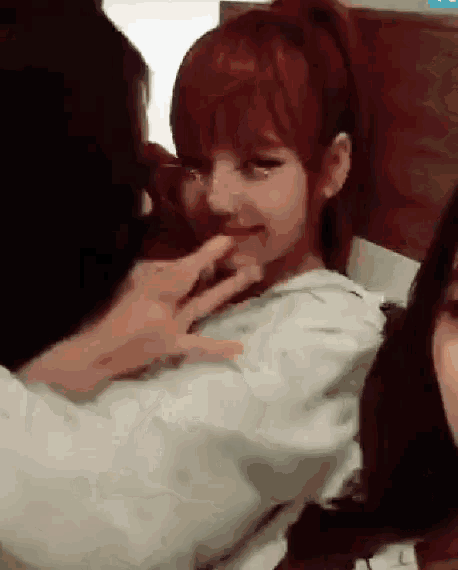 a man is touching a woman 's face while sitting next to her .