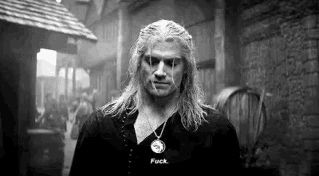 a black and white photo of a man with long hair and a necklace saying `` fuck '' .
