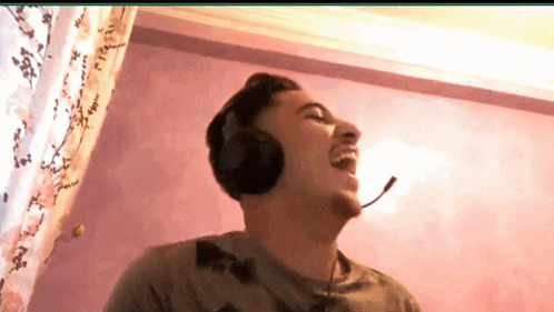 a man wearing headphones and a microphone laughing