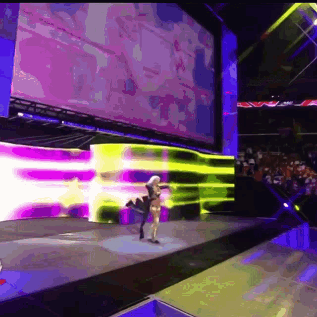 a woman is dancing on a stage in front of a crowd