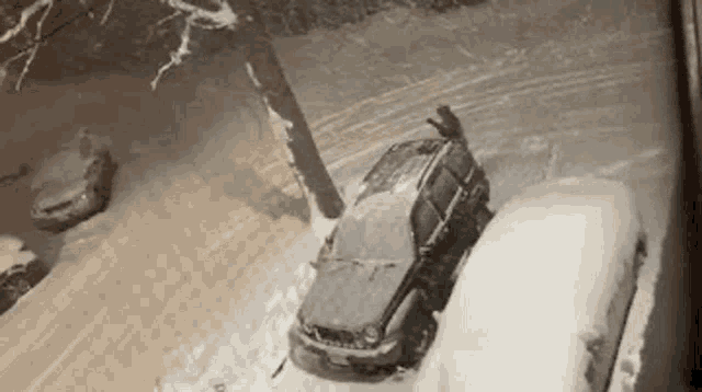 a jeep is parked in the snow with a person on top of it .