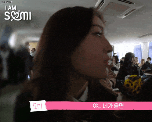 a girl sitting in a classroom with the words i am somi on the top