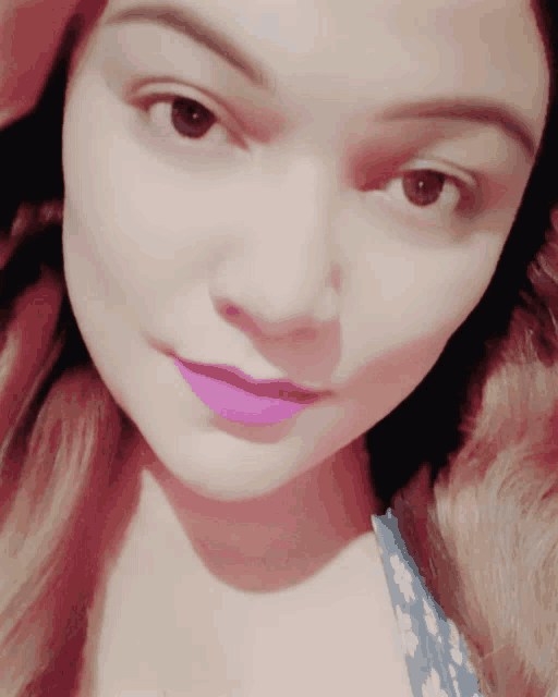 a woman with purple lipstick on her lips looks at the camera