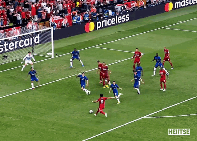 a soccer game is being played on a field with a mastercard ad in the background
