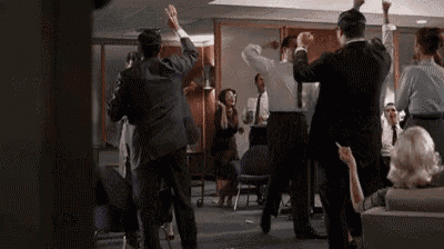 a group of people in suits and ties are dancing in a room .