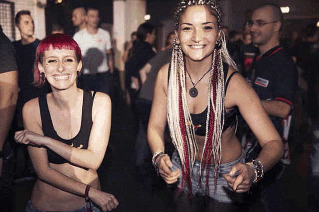 two women are posing for a picture with one wearing a black tank top that says ' abercrombie & fitch ' on the front