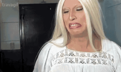 a woman with blonde hair and a white shirt is making a face .
