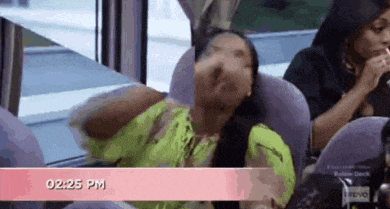 a woman in a neon green shirt is sitting on a bus at 2:25 pm .