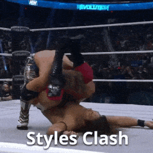 two men are wrestling in a wrestling ring with the words `` styles clash '' written above them .