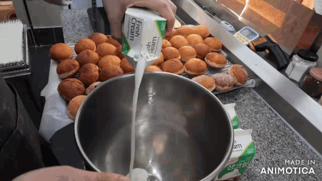 a person pouring fresh cream into a metal bowl