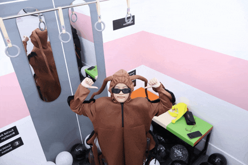 a person in a monkey costume is standing in front of a sign that says ' e ' on it