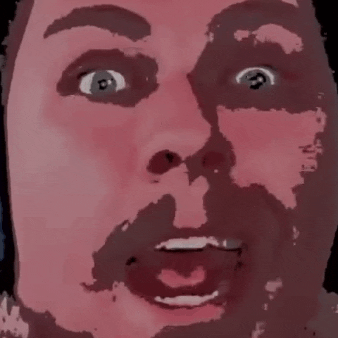 a close up of a man 's face with a beard and a surprised look on his face