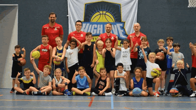 a group of kids are posing for a picture in front of a banner that says high five