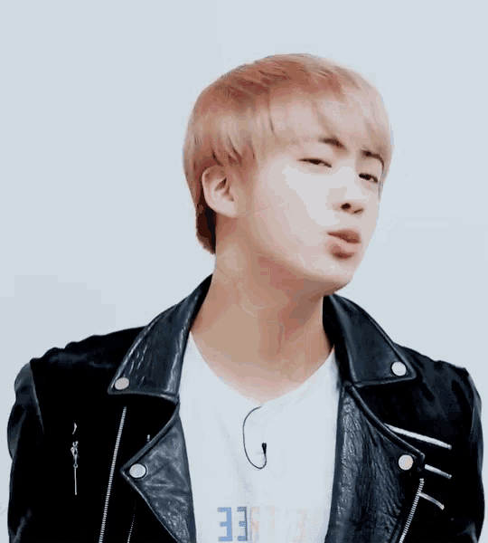 a close up of a person wearing a leather jacket and a white t-shirt .