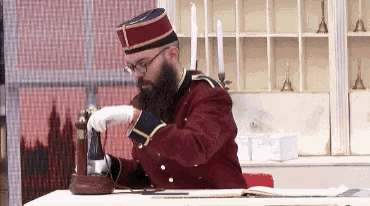 a man with a beard is sitting at a table with a book