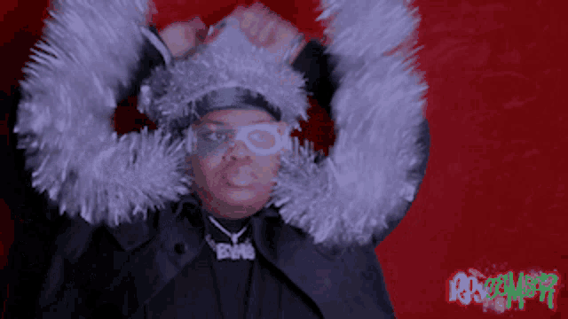 a person wearing a tinsel hat and a necklace that says bm