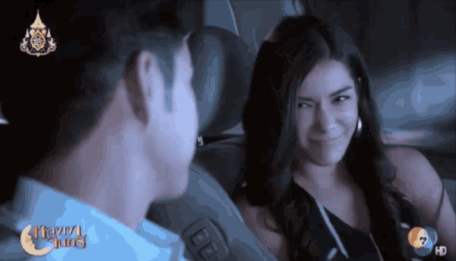 a man and a woman are sitting in a car with the number 7 on the bottom left