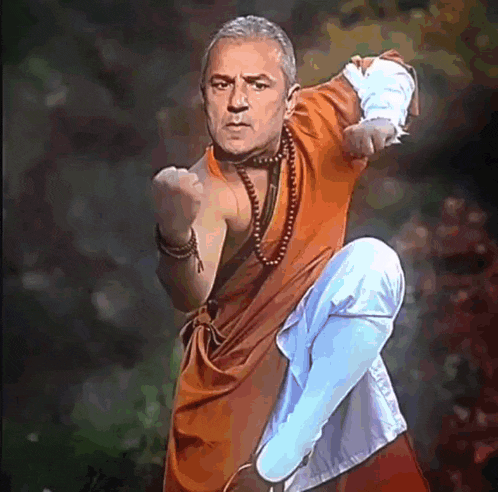 a man dressed as a monk is making a karate pose
