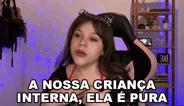 a girl is sitting in a chair with the words " a nossa criança interna ela e pura " written above her