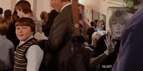 a group of people are standing in a room and the word heart is on the bottom right