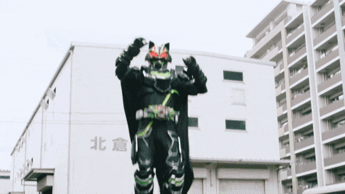 a man in a black costume stands in front of a building with chinese writing on it