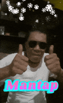 a man wearing sunglasses gives a thumbs up with the word mantas in the background