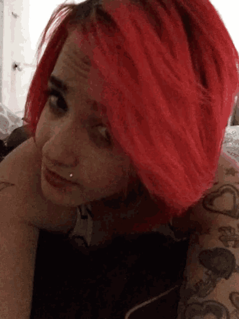 a woman with red hair is laying on a bed