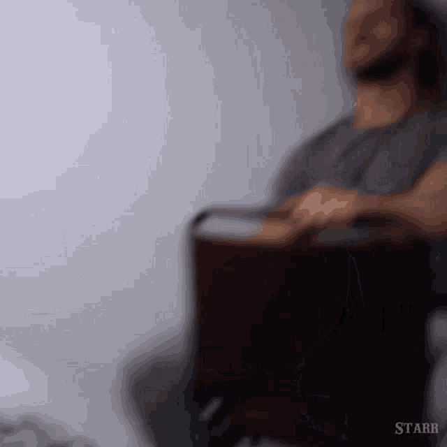 a man is sitting in a wheelchair with a cooler in his hand .