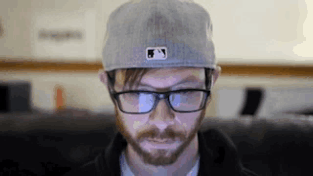 a man with a beard wearing a hat and glasses .