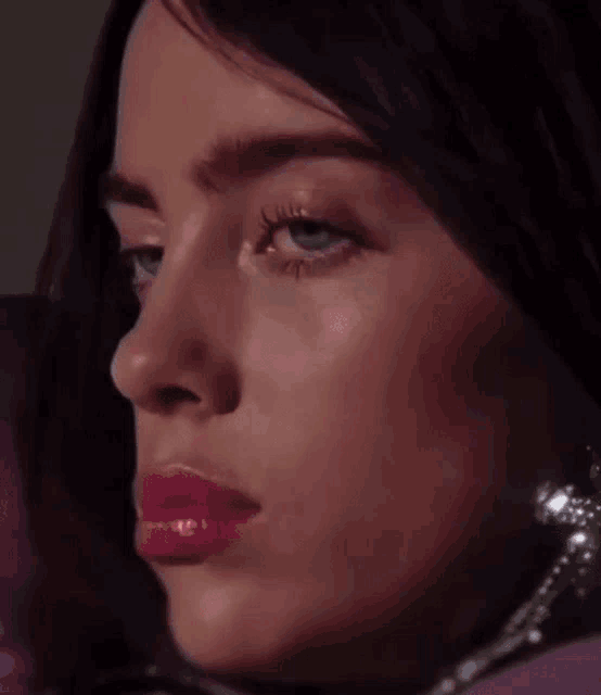 a close up of a woman 's face with pink lipstick on her lips .