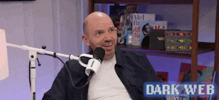 a bald man is sitting in front of a microphone with the words dark web on the bottom .