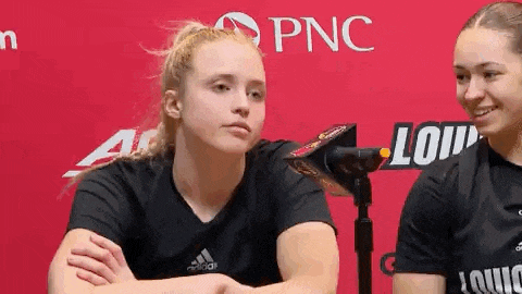 two women are sitting next to each other in front of a microphone at a press conference .