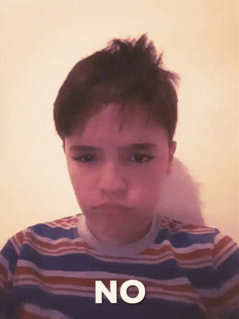 a young boy wearing a striped shirt with the word no on it