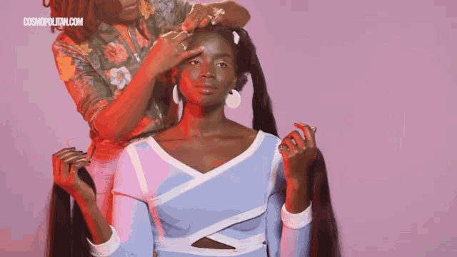 a woman is getting her hair done in front of a pink background with cosmopolitan.com written on it