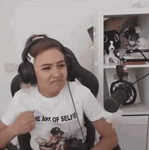 a woman wearing headphones is sitting in front of a microphone in a room .