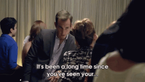 a man in a suit talks to a woman in a crowd and says it 's been a long time since you ve seen your