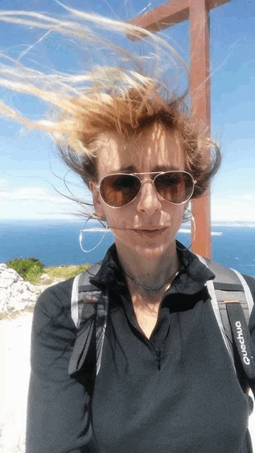 a woman wearing sunglasses and a black shirt that says o'neill on it