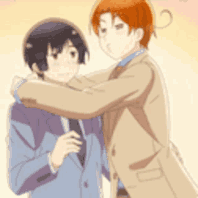 a man in a suit is hugging another man in a suit .