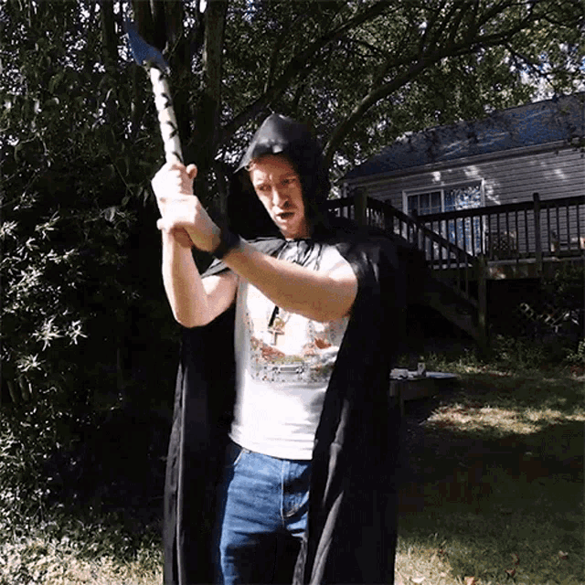 a man in a hooded cape holds a sword
