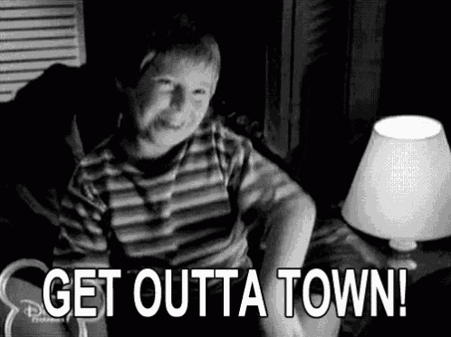 a black and white photo of a boy sitting on a couch with the words `` get outta town '' written on it .